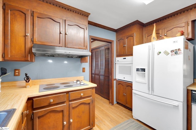 202 Mornington Ct, Simpsonville, SC 29681 - kitchen featuring light countertops, white appliances, under cabinet range hood, light wood-style floors, and brown cabinets