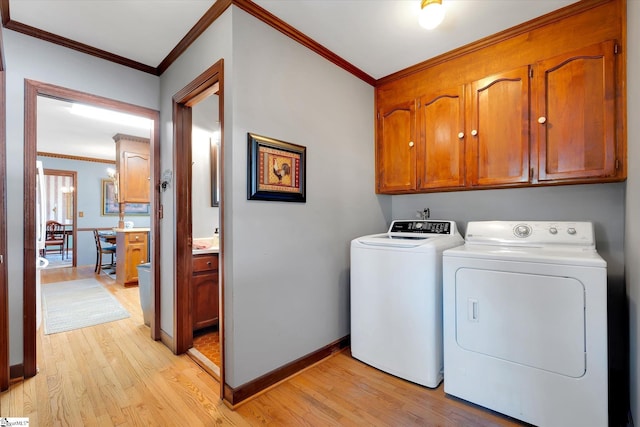 202 Mornington Ct, Simpsonville, SC 29681 - laundry room with cabinet space, ornamental molding, light wood-type flooring, and washer and dryer