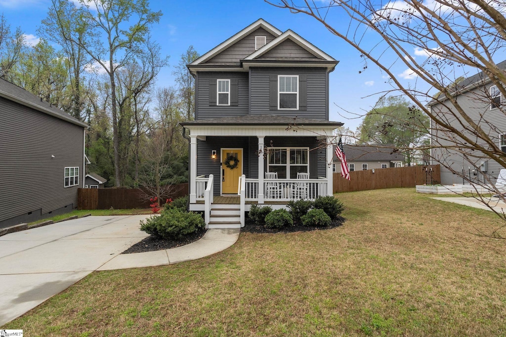 view of front of home with covered porch, a front yard, driveway, and fence