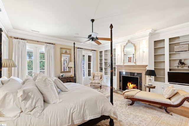 bedroom with a lit fireplace, visible vents, ornamental molding, and a ceiling fan