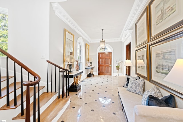 entrance foyer featuring baseboards, stairs, and crown molding