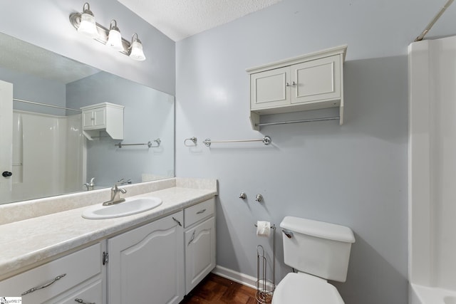 bathroom with toilet, a shower, vanity, and a textured ceiling