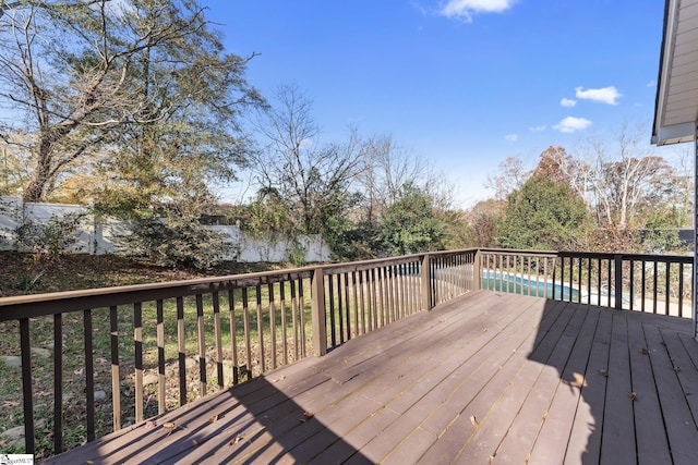 wooden terrace with a fenced in pool