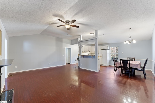living room with baseboards, ceiling fan with notable chandelier, lofted ceiling, and dark wood finished floors