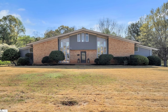 mid-century home with brick siding and a front yard