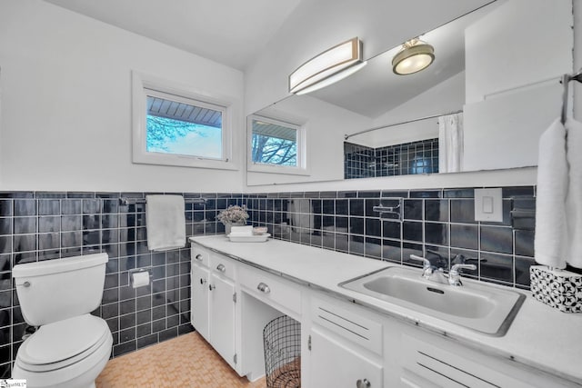 bathroom with a shower with curtain, vanity, lofted ceiling, tile walls, and toilet