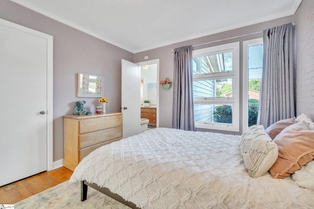 bedroom featuring ornamental molding and wood finished floors