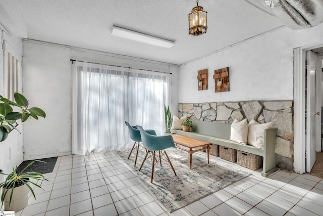 sitting room featuring tile patterned flooring, a chandelier, and a textured ceiling