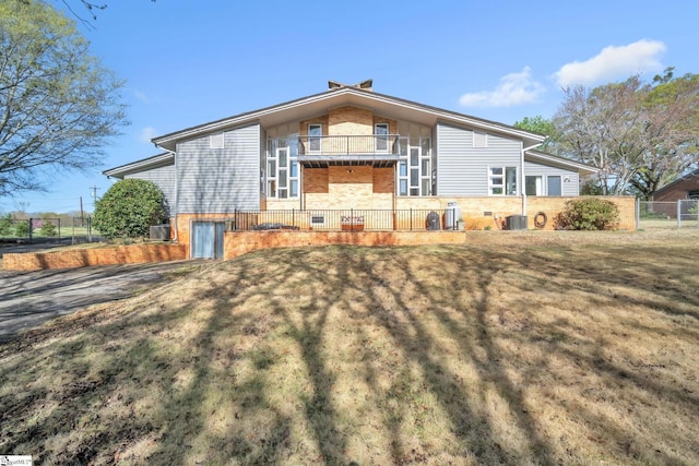 view of front of home with brick siding, fence, and a front lawn