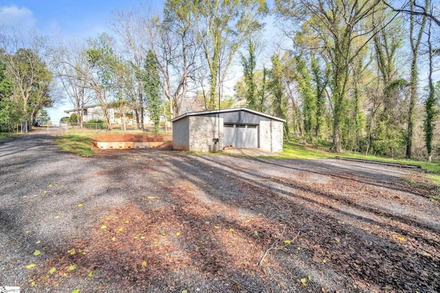 view of outdoor structure with driveway and an outbuilding