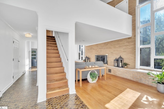 stairway featuring visible vents, a high ceiling, a wood stove, and plenty of natural light