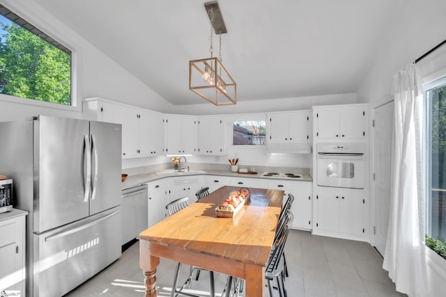 kitchen with light countertops, a sink, stainless steel appliances, and plenty of natural light
