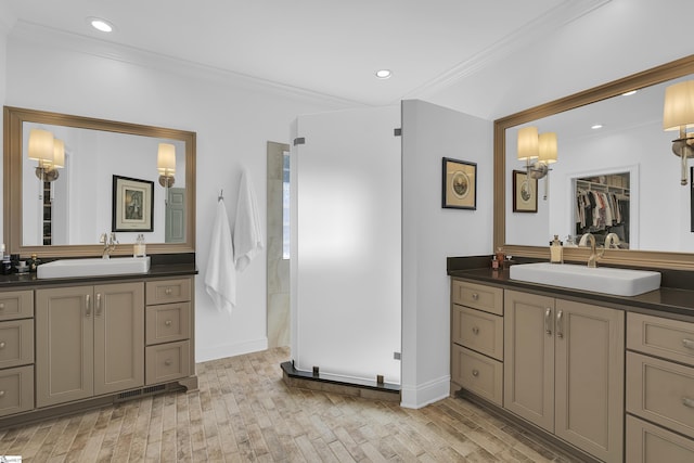 full bathroom featuring a sink, ornamental molding, and two vanities