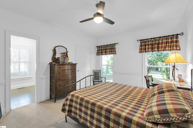 bedroom featuring ornamental molding, a ceiling fan, and light carpet