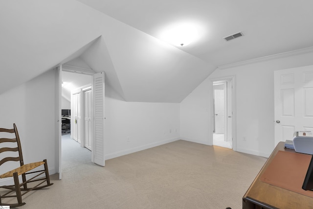 office area with baseboards, lofted ceiling, visible vents, and light carpet