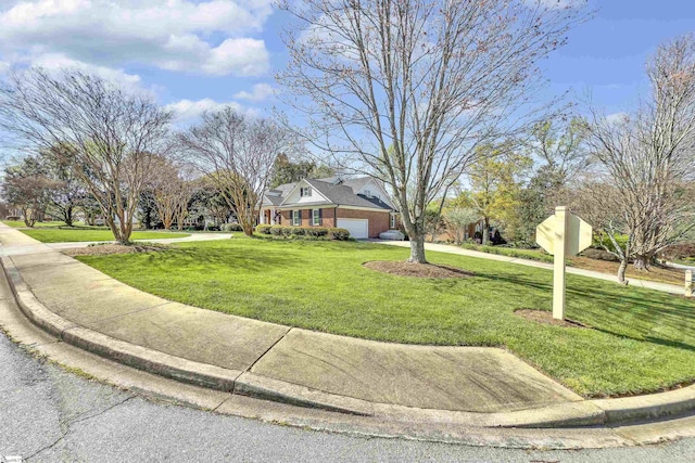 view of front of property with a front yard, an attached garage, brick siding, and concrete driveway
