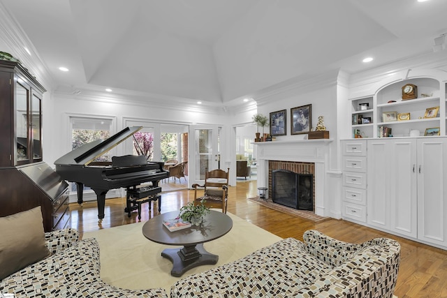 living room with recessed lighting, ornamental molding, built in features, a fireplace, and wood finished floors