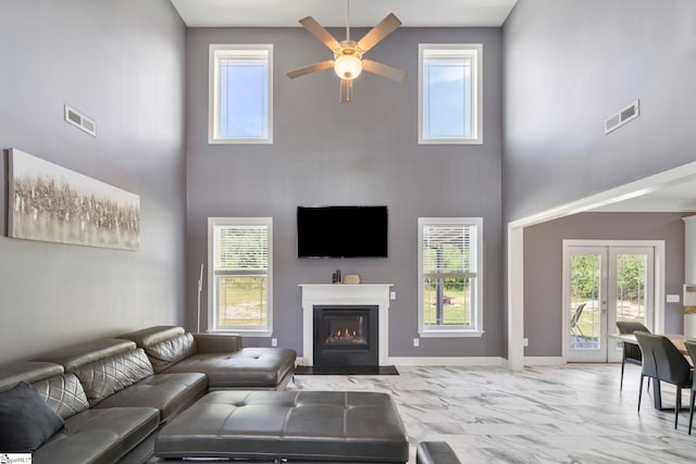 living room with marble finish floor, ceiling fan, visible vents, and a healthy amount of sunlight