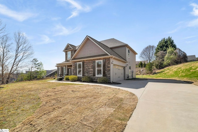 craftsman-style house with stone siding, concrete driveway, and a front yard