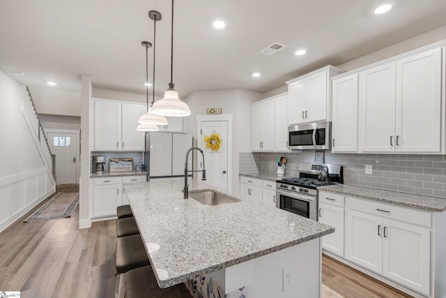 120 Marshfield Trl, Simpsonville, SC 29680 - kitchen with stainless steel appliances, a sink, a center island with sink, a kitchen breakfast bar, and pendant lighting