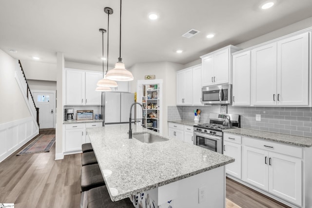 120 Marshfield Trl, Simpsonville, SC 29680 - kitchen featuring stainless steel appliances, a breakfast bar, visible vents, a sink, and a center island with sink