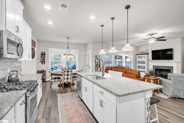120 Marshfield Trl, Simpsonville, SC 29680 - kitchen with stainless steel appliances, a sink, a fireplace, open floor plan, and ceiling fan
