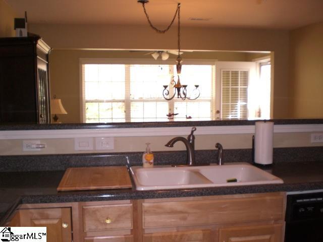 kitchen featuring a sink, dark countertops, a notable chandelier, and dishwasher