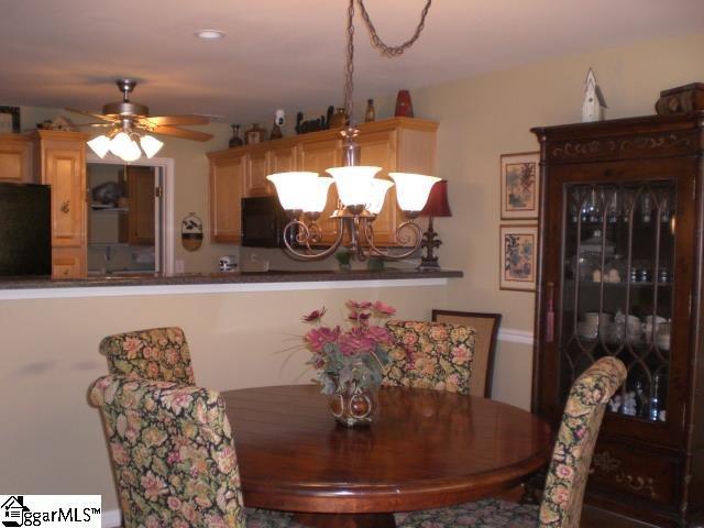 dining space with ceiling fan with notable chandelier