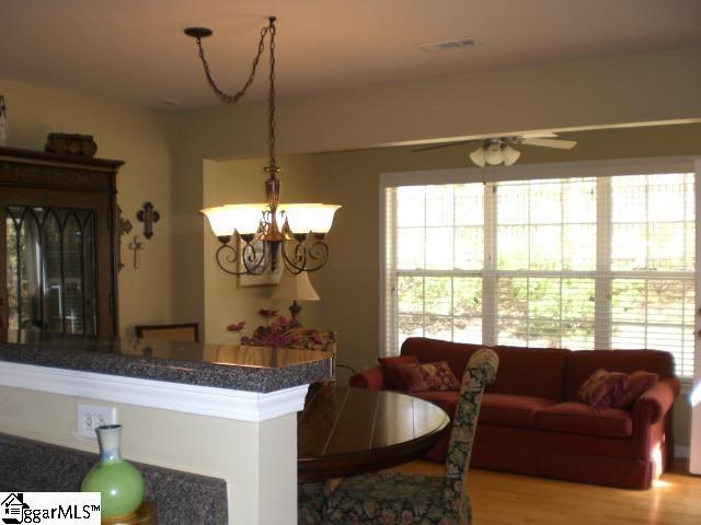 dining room with visible vents, ceiling fan with notable chandelier, and wood finished floors