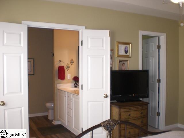 bedroom with baseboards, connected bathroom, and a sink