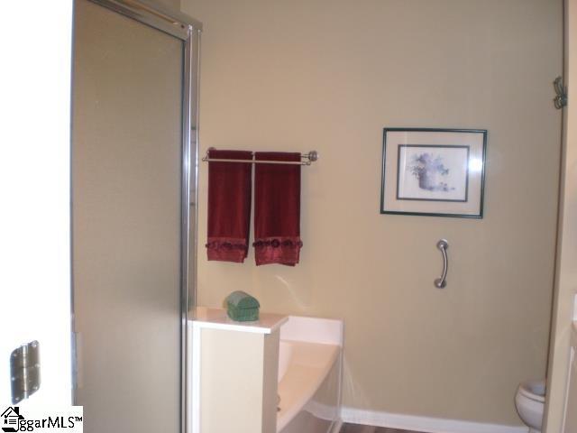 full bathroom with an enclosed shower and toilet