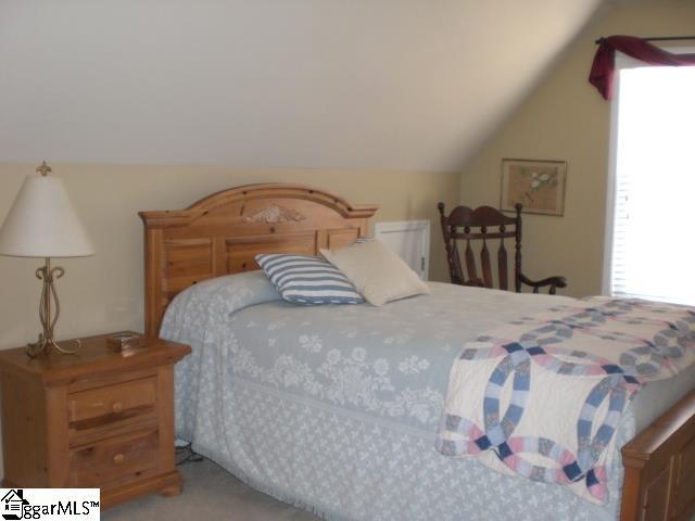 bedroom featuring carpet floors and vaulted ceiling