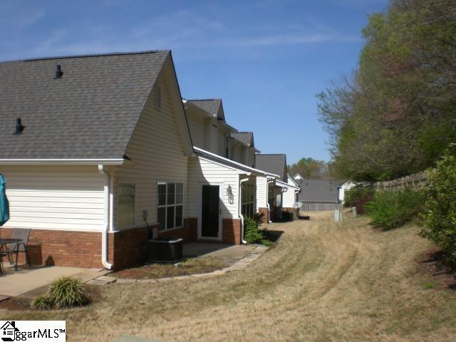 view of side of property with a patio, brick siding, a lawn, a shingled roof, and cooling unit