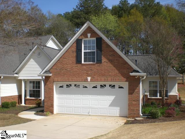 traditional-style home with brick siding, driveway, and an attached garage