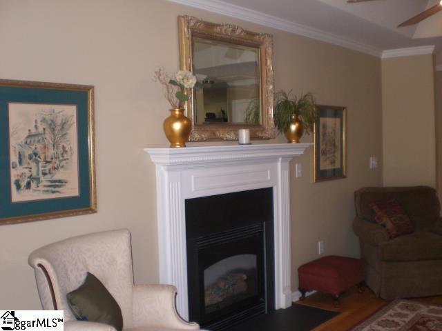 living room with ornamental molding and a fireplace