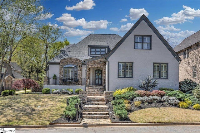 tudor home with stone siding, brick siding, and roof with shingles