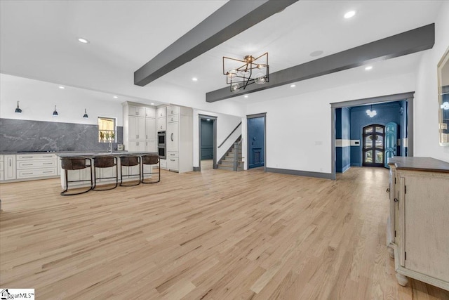 interior space featuring stairs, baseboards, beamed ceiling, light wood-style floors, and recessed lighting
