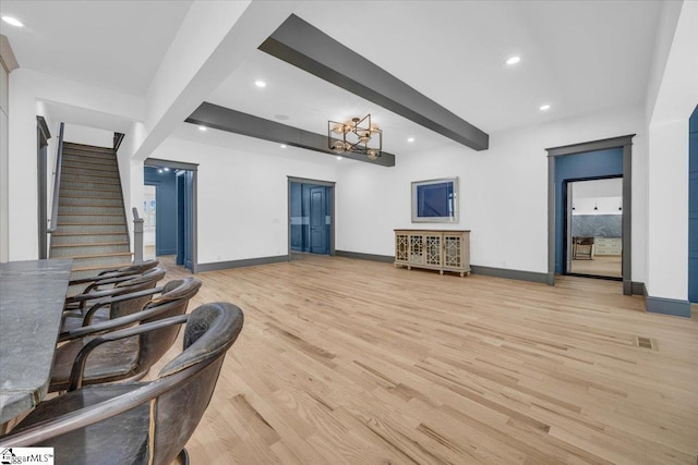 living room featuring stairs, baseboards, beamed ceiling, light wood-style floors, and recessed lighting