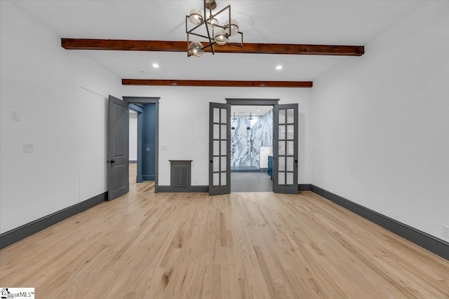 unfurnished room with french doors, wood finished floors, baseboards, visible vents, and an inviting chandelier