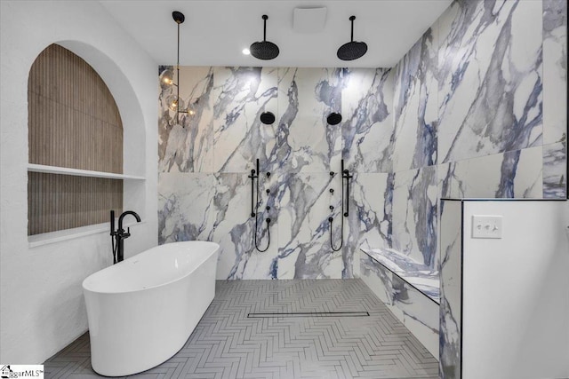full bath with tile walls, a marble finish shower, and a soaking tub