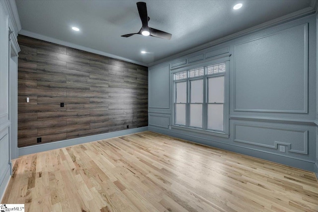 empty room with baseboards, ornamental molding, wood finished floors, recessed lighting, and a ceiling fan