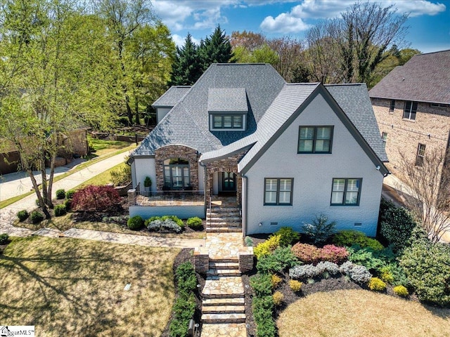 view of front of house with a shingled roof and stone siding
