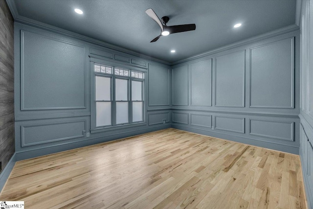empty room with crown molding, recessed lighting, ceiling fan, a decorative wall, and wood finished floors