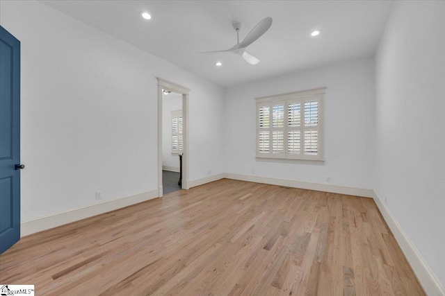 spare room with baseboards, light wood-style floors, a ceiling fan, and plenty of natural light