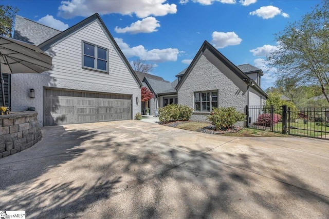 view of property exterior with fence, driveway, and a garage