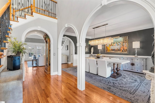 100 Breeds Hill Way, Greer, SC 29650 - entryway featuring crown molding, stairs, a towering ceiling, arched walkways, and light wood finished floors