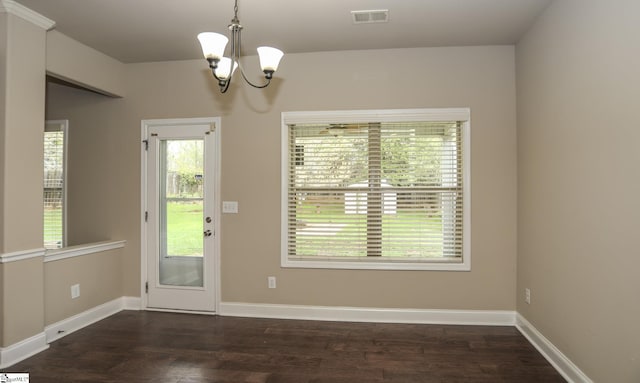 interior space featuring a notable chandelier, dark wood-style floors, baseboards, and visible vents