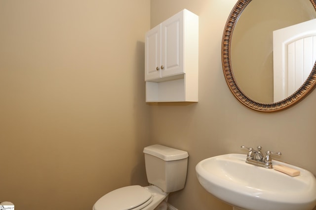 bathroom with baseboards, a sink, and toilet