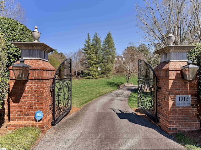 view of street with a gated entry, a gate, and aphalt driveway