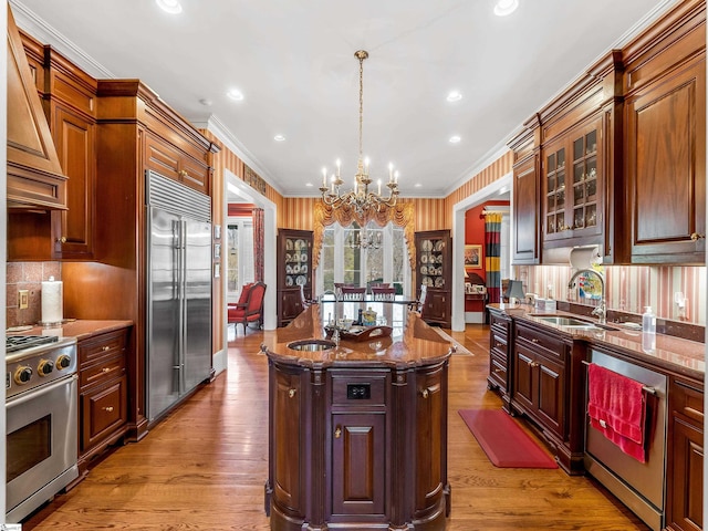 kitchen featuring a sink, stainless steel appliances, a chandelier, and crown molding